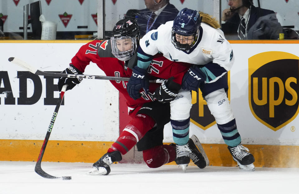 Ottawa's Jincy Roese (71) fights to keep the puck from New York's Jessie Eldridge (9) during the first period of a PWHL hockey game Wednesday, Feb. 28, 2024, in Ottawa, Ontario. (Sean Kilpatrick/The Canadian Press via AP)