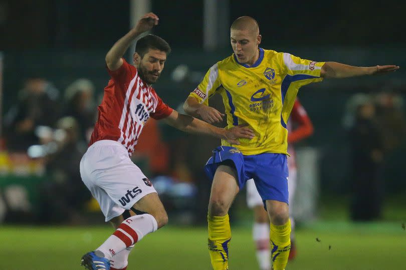 Exeter City's Danny Butterfield is challenged by Warrington Town's Scott Metcalfe during the FA Cup first round match at Cantliner Park, Warrington, 2014 -Credit:Dave Thompson/PA Wire