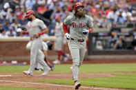 Philadelphia Phillies' Brandon Marsh runs up the first baseline after being walked with the bases loaded during the third inning of a baseball game against the New York Mets, Tuesday, May 14, 2024, in New York. Phillies designated hitter Kyle Schwarber scores a run in the background. (AP Photo/Adam Hunger)
