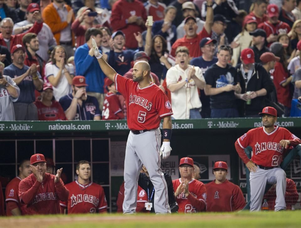 Los Angeles Angels' Albert Pujols (5) steps out of the visitors' dugout to acknowledge the applause from the crowd after hitting his career 500th home run, off Washington Nationals' Taylor Jordan in the fifth inning of a baseball game in Washington, Tuesday, April 22, 2014. (AP Photo/Pablo Martinez Monsivais)