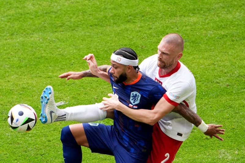 Bartosz Salamon (z prawej) i Holender Memphis Depay walczą o piłkę podczas meczu piłkarskiego grupy D UEFA EURO 2024 pomiędzy Polską a Holandią na stadionie Volksparkstadion Marcus Brandt/dpa