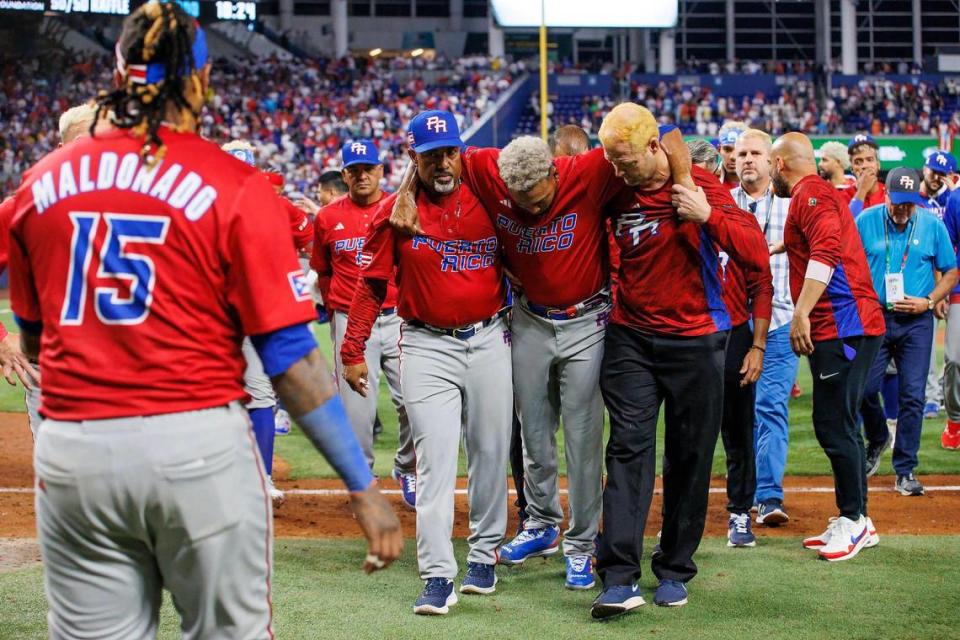 Puerto Rico pitcher Edwin Diaz (39) is being helped by team pitching coach Ricky Bones and medical staff after the the Pool D game against Dominican Republic at the World Baseball Classic at loanDepot Park on Wednesday, March 15, 2023, in Miami, Fla.