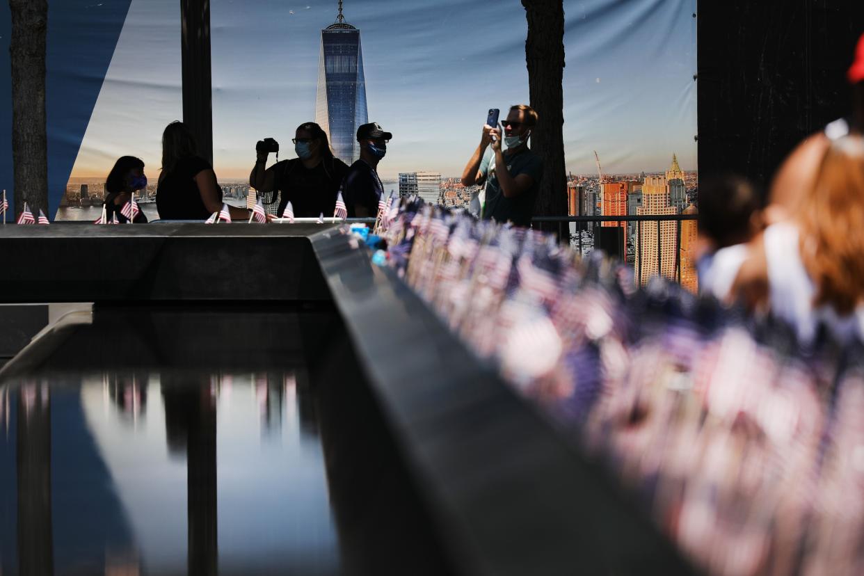 People gather at the 9/11 memorial plaza on the first day that it has reopened after closing for three months due to the coronavirus on on July 4, 2020, in New York City. While the museum at the site remains closed, on Saturday, first responders, military and others will be allowed to stand beside the memorial pools that sit in the footprints where the twin towers used to stand. Starting on Sunday the site will be open to the general public.