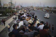 In this Saturday, March 28, 2020, photo, Indian migrant workers sit atop a bus, provided by the government, as others walk along an expressway to their villages following a lockdown amid concern over spread of coronavirus in New Delhi, India. Over the past week, India’s migrant workers - the mainstay of the country’s labor force - spilled out of big cities that have been shuttered due to the coronavirus and returned to their villages, sparking fears that the virus could spread to the countryside. It was an exodus unlike anything seen in India since the 1947 Partition, when British colothe subcontinent, with the 21-day lockdown leaving millions of migrants with no choice but to return to their home villages. (AP Photo/Altaf Qadri)