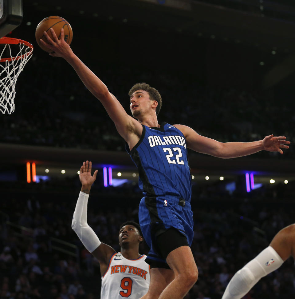 Orlando Magic forward Franz Wagner (22) lays in a basket over New York Knicks guard RJ Barrett during the first half of an NBA basketball game Monday, Oct. 24, 2022, in New York. (AP Photo/John Munson)