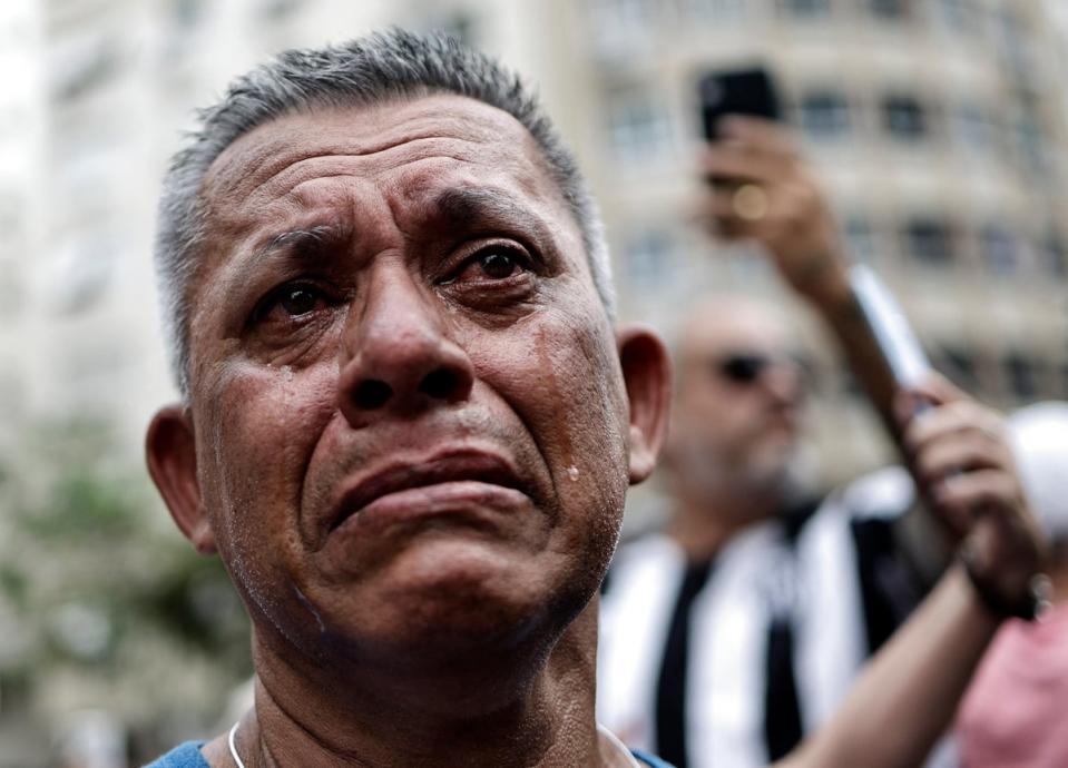 A fan reacts emotionally as Pelé’s casket passes by in Santos (REUTERS)