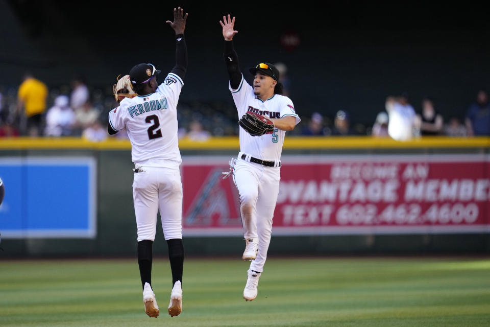 Arizona Diamondbacks center fielder Alek Thomas (5) and Diamondbacks shortstop Geraldo Perdomo (2) celebrate after a baseball game against the Los Angeles Dodgers Sunday, April 9, 2023, in Phoenix. The Diamondbacks won 11-6. (AP Photo/Ross D. Franklin)