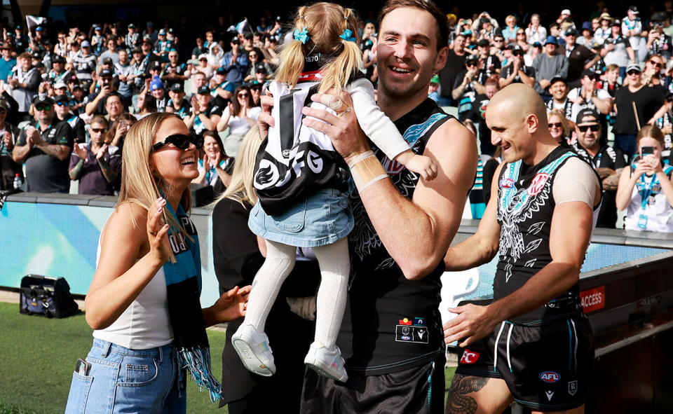 Jeremy Finlayson, pictured here with wife Kellie and daughter Sophia before a game for Port Adelaide in 2023.