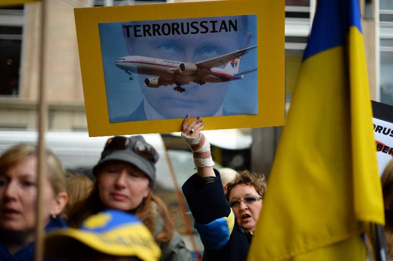 Members of the Australian Ukrainian community hold placards of Russian President Vladimir Putin during a protest rally in Sydney on July 19, 2014