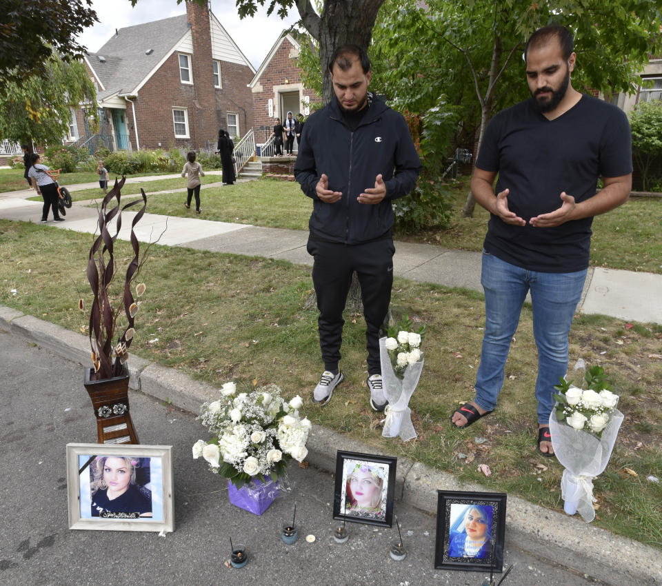 Mohammad Aljanabi, left, and Ali Aljanabi, brothers of shooting victim, Saja Aljanabi, says prayers at their sister's memorial Sunday, Sept. 8, 2019, as they light candles around her memorial in Dearborn, Mich. Dearborn Police Chief Ronald Haddad said Thursday, Sept. 12, 2019, that the 14-year-old, a 13-year-old and 17-year-old are being held in connection with last week's killing of Saja Aljanabi and they could be involved in other crimes in the area. (Todd McInturf/Detroit News via AP)