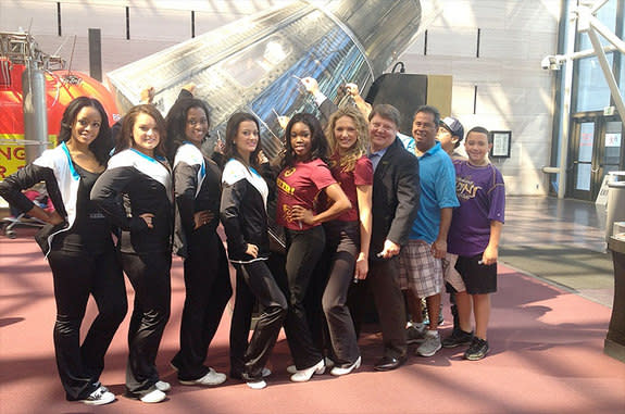 Project MERCCURI and Science Cheerleader team members take swab samples from John Glenn's 'Friendship 7' Mercury capsule at the National Air and Space Museum.