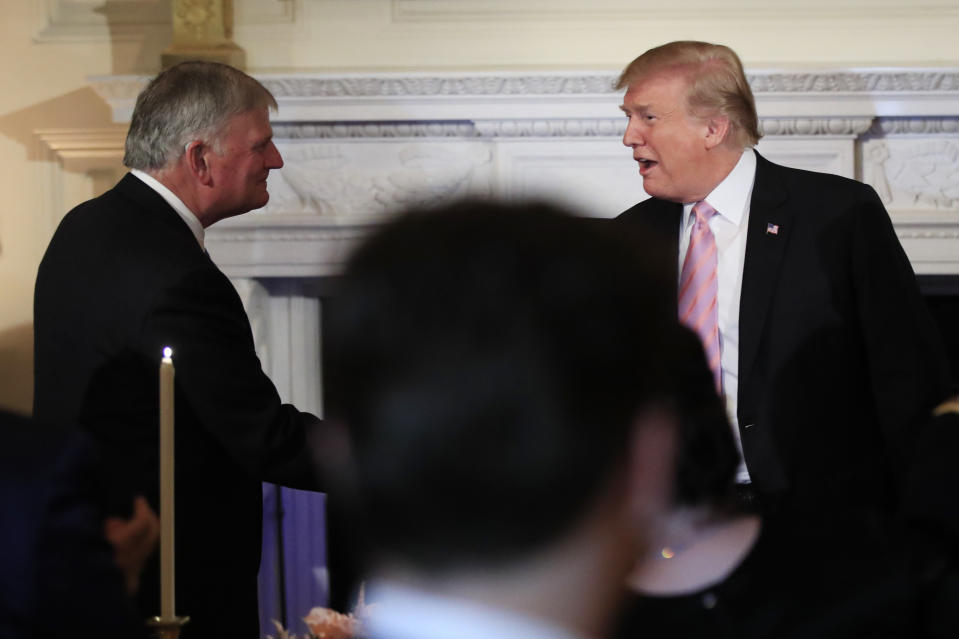 FILE - In this Wednesday, May 1, 2019, file photo, President Donald Trump greets Franklin Graham, left, son of Billy Graham, during a National Day of Prayer dinner gathering in the State Dining Room of the White House in Washington. Trump’s appeal to religious conservatives is a cornerstone of his political identity. But Joe Biden is a different kind of foe than Trump has faced before: one who makes faith a central part of his persona – often literally wearing it on his sleeve. (AP Photo/Manuel Balce Ceneta, File)