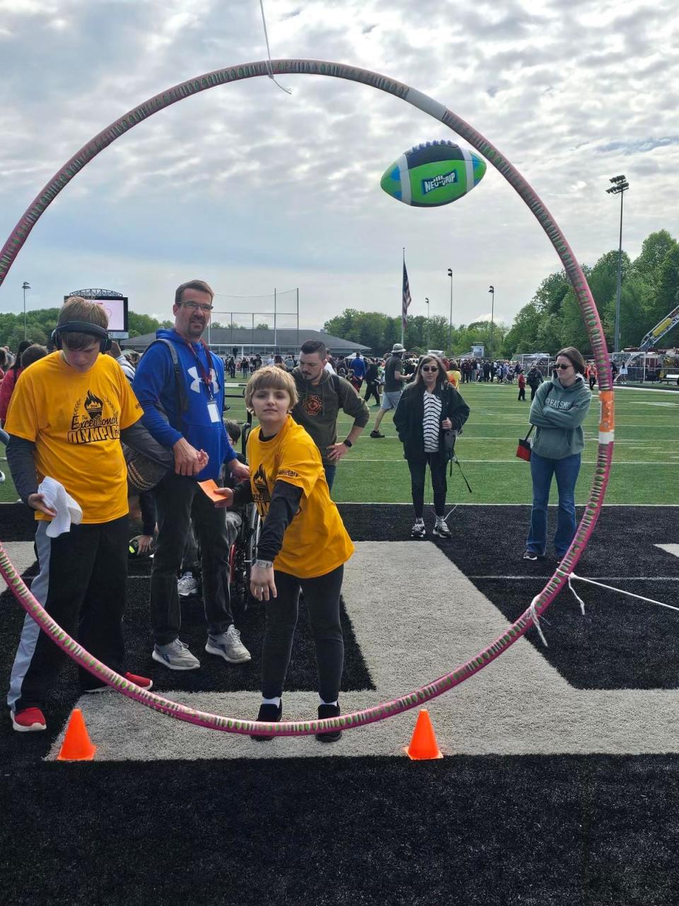 Aleria DiGrangia with the Stark County Learning Center tosses a football through a target Friday during the 37th annual Exceptional Olympics at Wakefield Stadium at Perry High School.