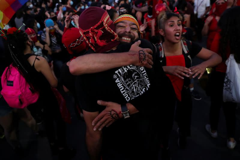 Gente se abraza durante el referéndum sobre una nueva constitución en Santiago, Chile.