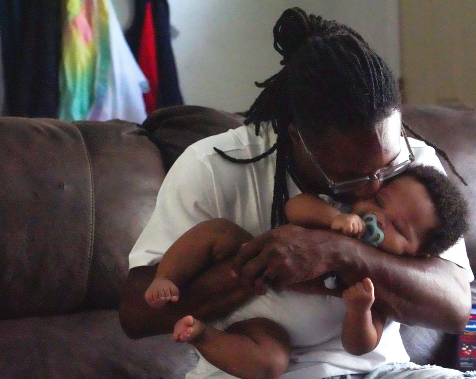 Brandon Woodson, 32, kisses his 4-month-old son, Blaze Woodson, as he played games with his family at their home in Indianapolis on June 15, 2022.