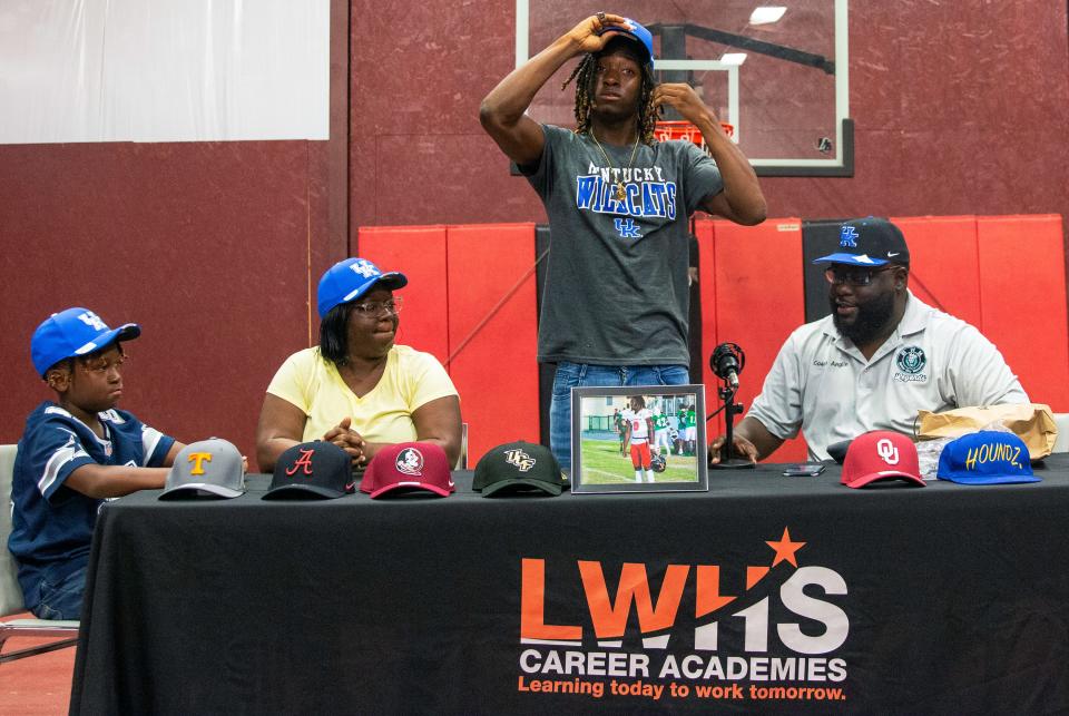 Lake Wales senior Jaremiah Anglin Sr. puts on a Kentucky cap after committing to the SEC school on Saturday night at a commitment ceremony at the Youth Sports Academy in Lake Wales.