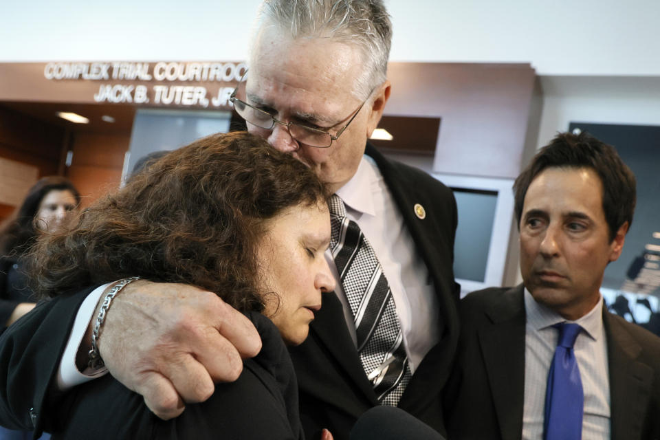 Former Marjory Stoneman Douglas High School School Resource Officer Scot Peterson kisses his wife, Lydia Rodriguez, as he gives a media interview after he was found not guilty on all charges at the Broward County Courthouse in Fort Lauderdale, Fla., on Thursday, June 29, 2023. Peterson was acquitted of child neglect and other charges for failing to act during the Parkland school massacre, where 14 students and three staff members were murdered. (Amy Beth Bennett/South Florida Sun-Sentinel via AP, Pool)