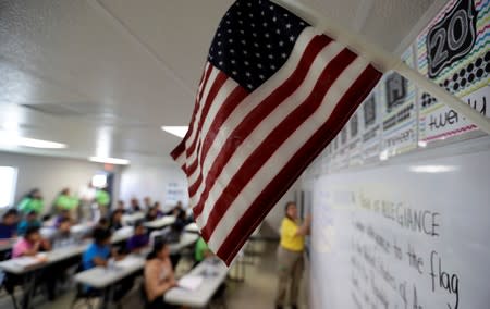 A teacher uses the Pledge of Allegiance in a reading class the U.S. government's newest holding center for migrant children in Carrizo Springs