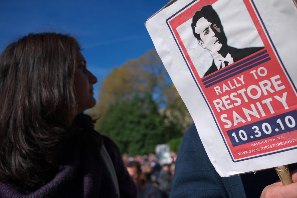 A woman stands next to a placard for Jon Stewart as people gather on the Mall to attend the Rally to Restore Sanity and/or Fear on the National Mall October 30, 2010 in Washington, DC. Thousands of people stream into Washington's National Mall for the rally billed as an antidote to the ugly political mood polarizing the US in the run-up to midterm elections on November 2, hosted by liberal comics Jon Stewart and Stephen Colbert.     AFP PHOTO/Mandel NGAN (Photo credit should read MANDEL NGAN/AFP/Getty Images)