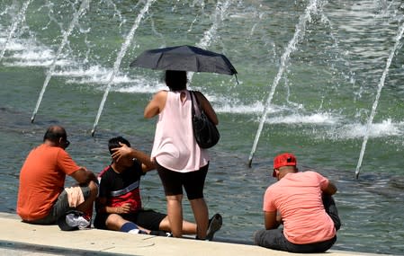 Tourists attempt to cool off at a fountain at the World War II Memorial on the National Mall during a heat wave, in Washington, DC