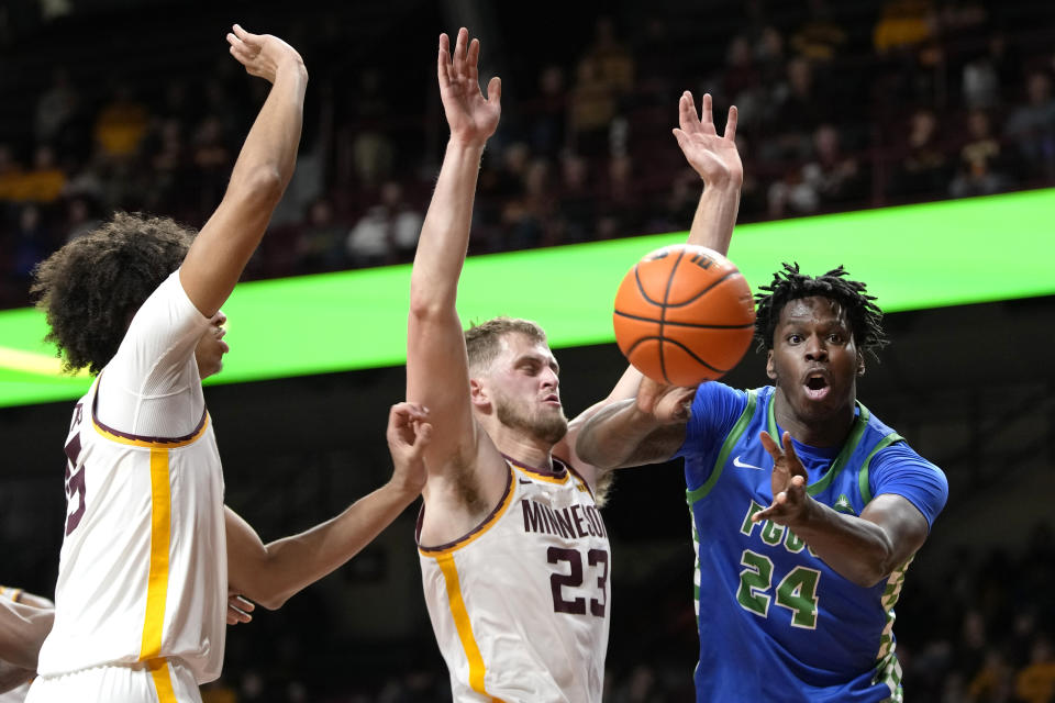 Florida Gulf Coast forward Josiah Shackleford (24) passes as Minnesota forward Kadyn Betts, left, and forward Parker Fox (23) defend during the second half of an NCAA college basketball game Saturday, Dec. 9, 2023, in Minneapolis. (AP Photo/Abbie Parr)