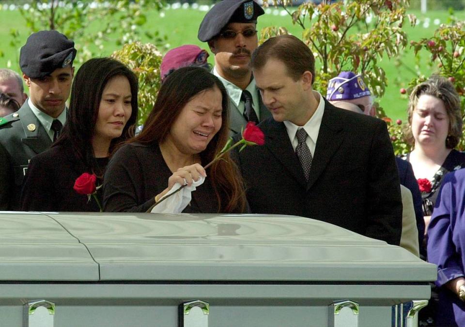 Jamie Miller, the pregnant widow of Staff Sgt. Fred Miller who was killed in Iraq last week, tearfully places a rose on her husband’s casket at the small, rural New Jersey cemetery on Sept. 29, 2003.