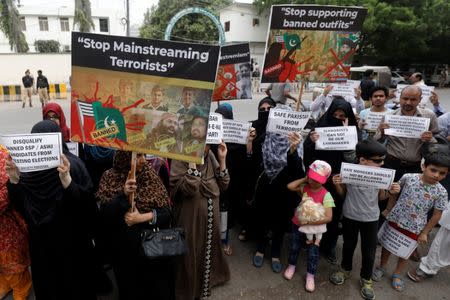 FILE PHOTO: People hold signs as they chant slogans against the participation of banned outfits to take part in general elections, during a protest outside election commission office in Karachi, Pakistan July 16, 2018. REUTERS/Akhtar Soomro/File Photo