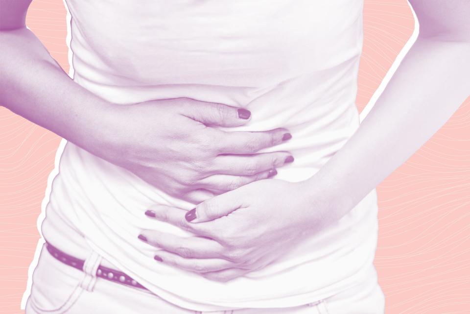 Young woman having abdominal pain, upset stomach or menstrual cramps on a designed background