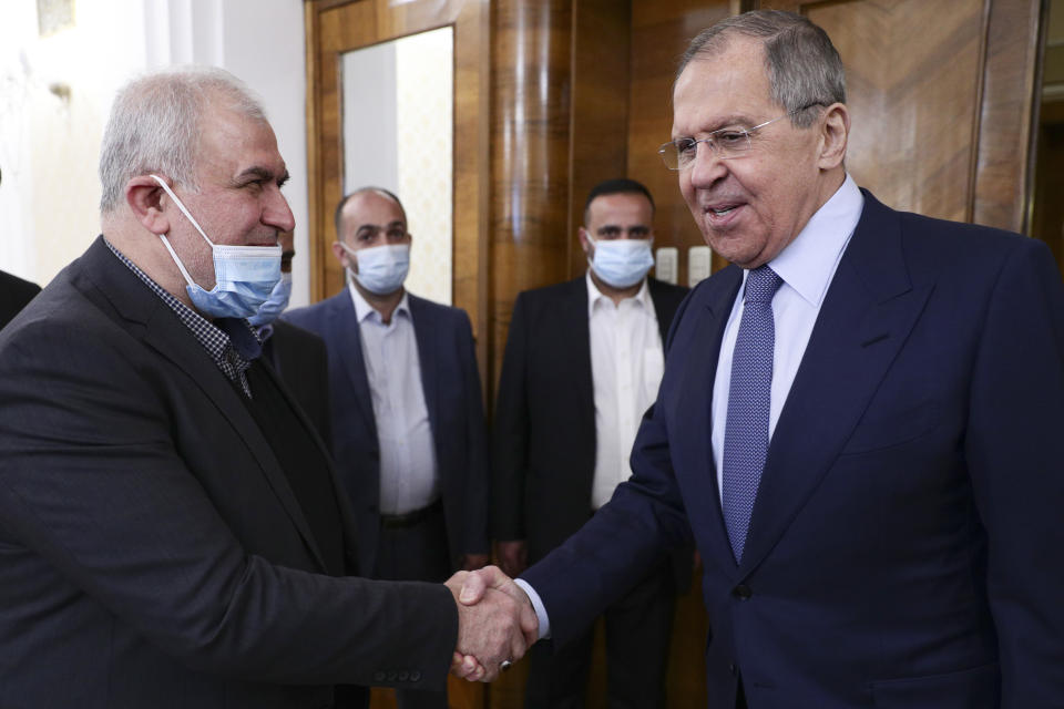 In this photo released by Russian Foreign Ministry Press Service, Russian Foreign Minister Sergey Lavrov, right, shakes hands with the head of Hezbollah parliamentary bloc Mohamad Raad during their meeting in Moscow, Russia, Monday, March 15, 2021. (Russian Foreign Ministry Press Service via AP)