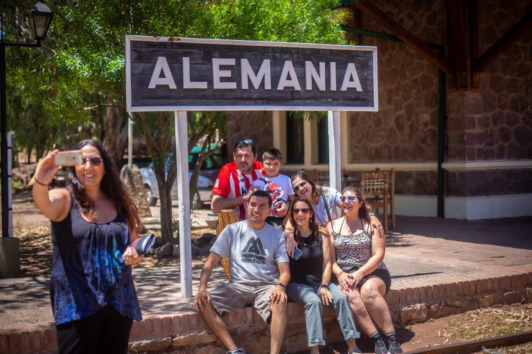 Un grupo de pobladores frente al cartel del pueblo