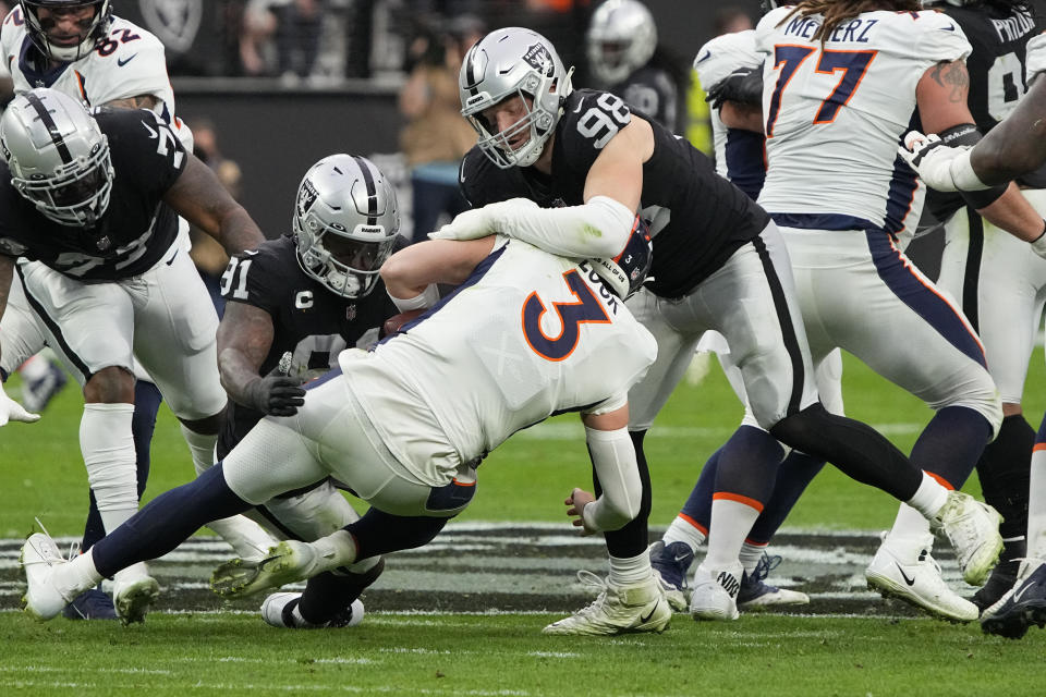 Las Vegas Raiders defensive end Maxx Crosby (98) sacks Denver Broncos quarterback Drew Lock (3) during the first half of an NFL football game, Sunday, Dec. 26, 2021, in Las Vegas. (AP Photo/Rick Scuteri)