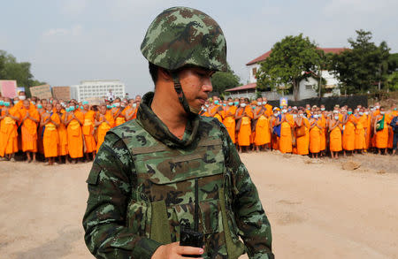 A soldier stands in front of Buddhist monks at Dhammakaya temple, in Pathum Thani province, Thailand February 23, 2017. REUTERS/Chaiwat Subprasom