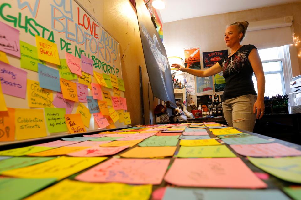 Sticky notes given to Mandy Fraser describing what people love about the city are seen in the foreground, as she describes how she used those words to paint her "Love Letters to New Bedford" campaign at her home studio.