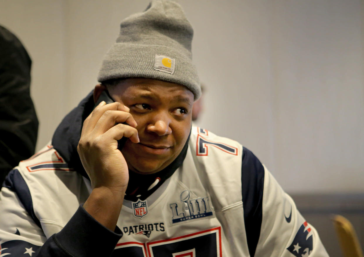 Trent Brown on the phone during Super Bowl media availability, presumably not talking to the Raiders. (Getty)