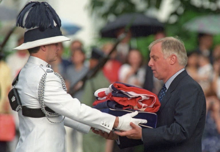 Hong Kong's last governor Chris Patten (R) receives the Union Jack after it was lowered for the last time at Government House on June 30, 1997. Colonial emblems have become a symbol of protest in the face of what many see as growing Beijing interference