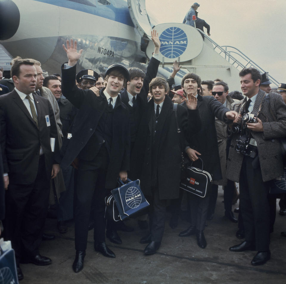 The Beatles arrive at New York's John F. Kennedy International Airport (formerly Idlewild), in New York, Feb. 7, 1964. From left: John Lennon (waving), Paul McCartney, Ringo Starr and George Harrison. (AP Photo)