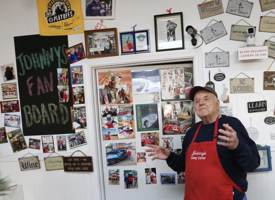 Johnny Biagioni, the owner of Johnny’s Candy Corner at York Beach for four decades, poses with his wall of photos. The wall showcases his customers, from sports celebrities to local families, who have shared their stories and memories with him.