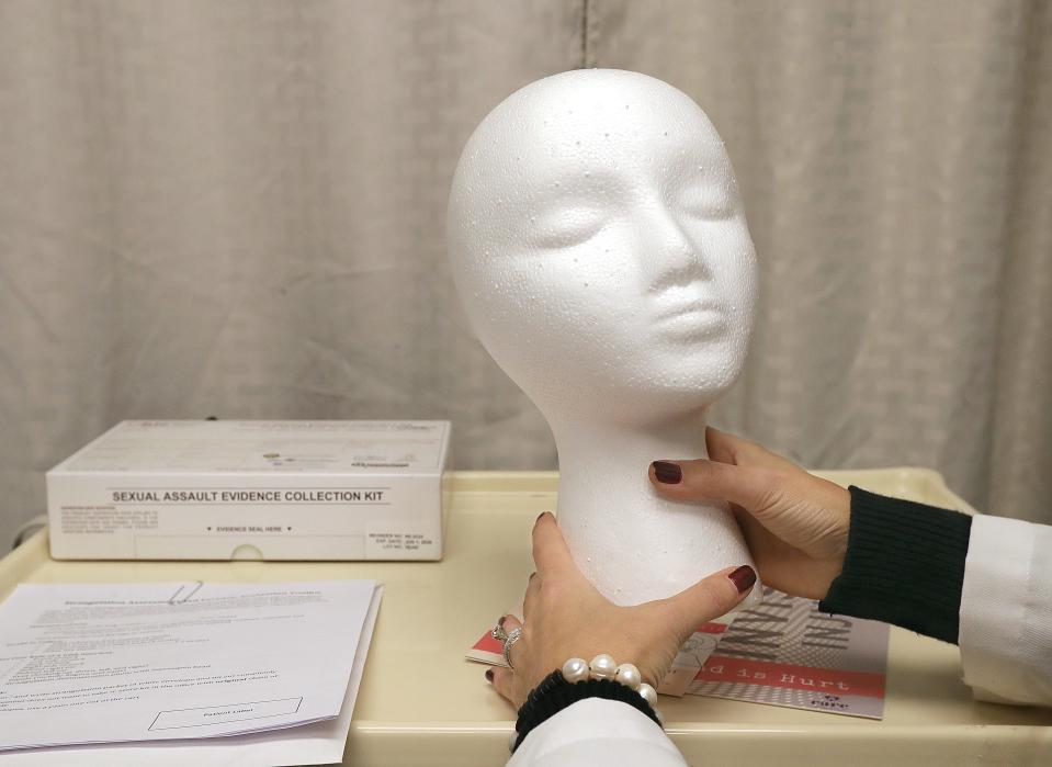 Lily Holderbaum, a forensic nurse at Cleveland Clinic Akron General, demonstrates how strangulation victims use a mannequin to show what happened to them.