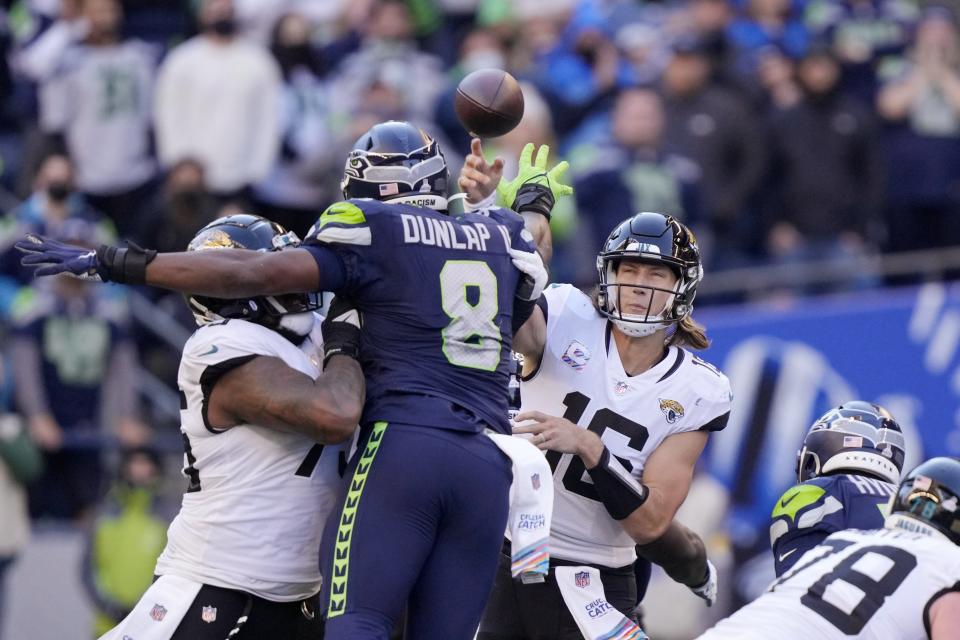 Seattle Seahawks defensive end Carlos Dunlap (8) puts a hand up as he tries to deflect a pass from Jacksonville Jaguars quarterback Trevor Lawrence (16) Sunday, Oct. 31, 2021, in Seattle.