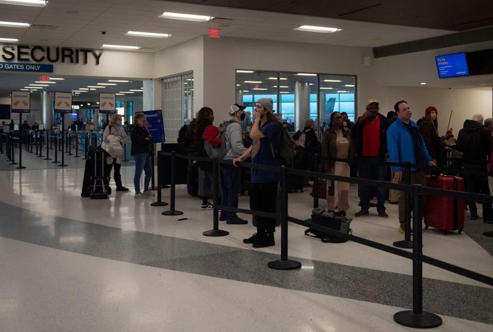 Will Ringer looks at flight delays listed while waiting in line to talk with a Southwest Airlines ticket agent.