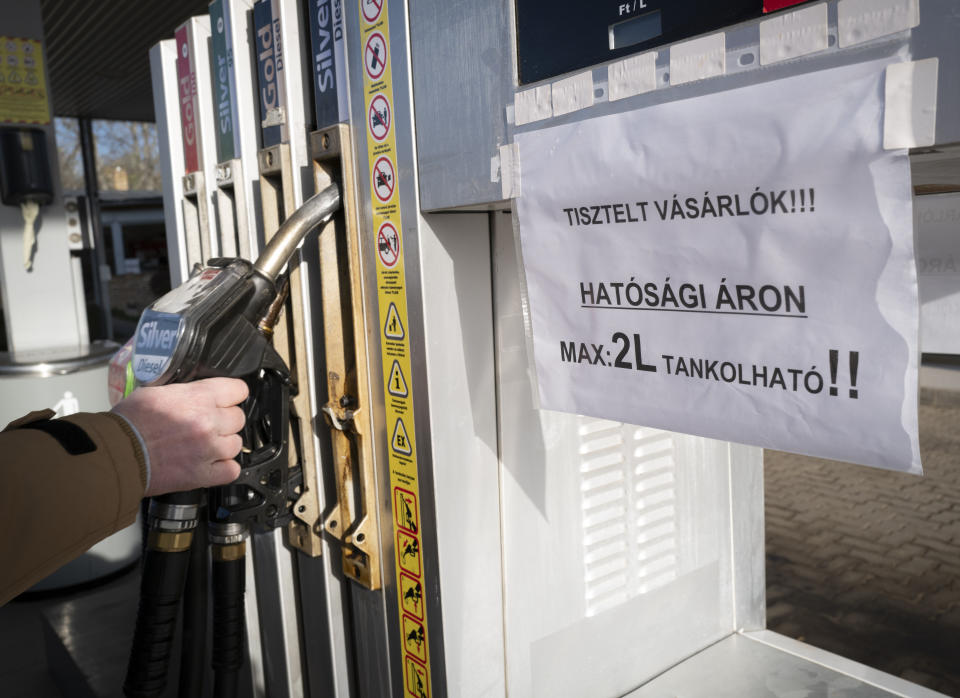 A view of a sign on a fuel pump at a petrol station reading 'Dear Costumers! You can purchase only 2 liters of fuel at the regulated price!' in Martonvasar Hungary, Thursday, Dec. 1, 2022. Drivers in Hungary are running into fuel shortages at filling stations as a government-imposed price cap on fuel squeezes independent stations and leaves the state energy company struggling to keep up with demand. (AP Photo/Bela Szandelszky)