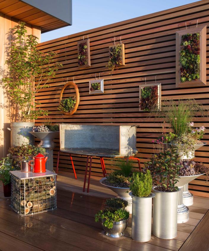 <p> Vertical gardening is ideal for maximizing the amount of greenery in smaller plots.&#xA0; </p> <p> There are lots of ways to incorporate it into a decked space, from hanging baskets to living walls. But these stunning succulent frames are an easy DIY project that will elevate any outdoor living zone. </p> <p> To recreate the look, you&apos;ll need to remove the glass and back of a deep picture frame, then staple a sheet of chicken wire or hardware cloth (available on Amazon) inside. Replace the back and fill the space between it and the wire grid with soil. Poke the roots of your succulent cuttings through the holes in the grid to create a tapestry of plants. Allow it to lay flat for a couple of weeks for them to establish in their new home before hanging the frames up onto a fence. </p> <p> This scene also uses reclaimed materials for unique furniture &#x2013; we particularly love the small coffee table. Create something similar using a gabion basket filled with logs or stones and topped with a square of timber. </p>