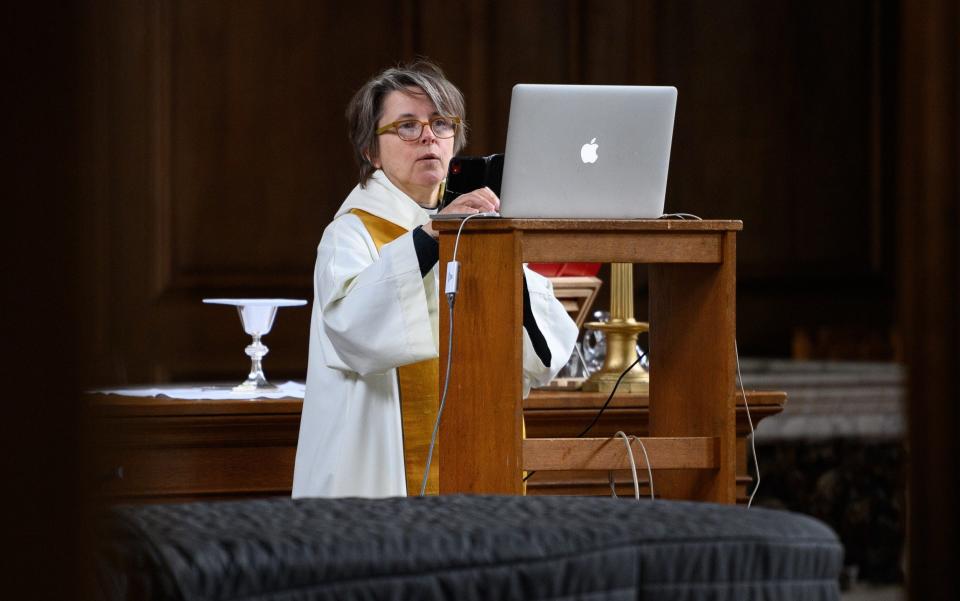 The reverend Lucy Winkett, rector of St James's Piccadilly, attempts to resolve a technical issue, minutes before delivering a service via webcam to the church's congregation while the pews remain empty on May 17, 2020 in London, England - Getty Images Europe