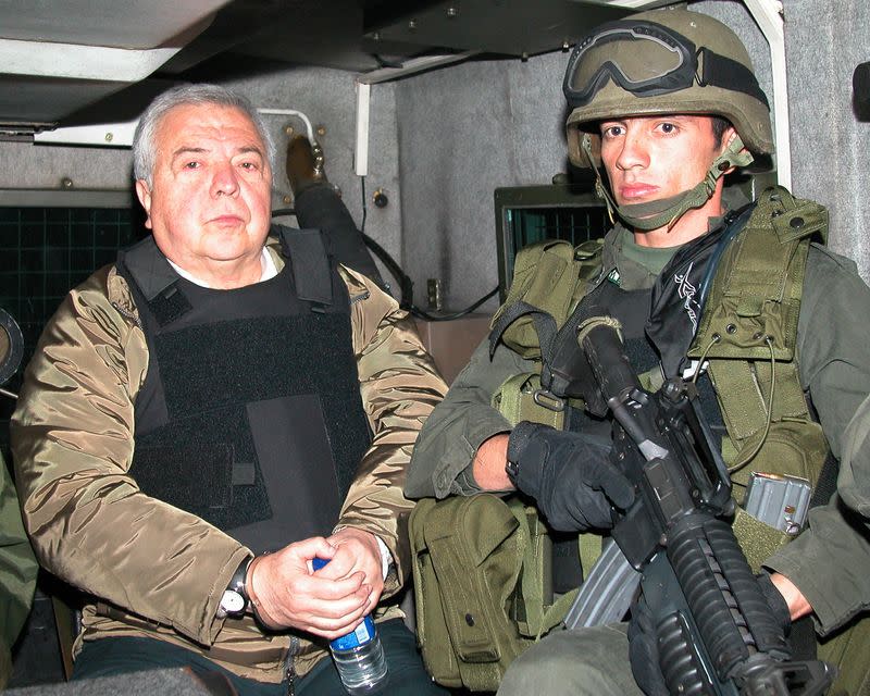 Foto de archivo. GIlberto Rodríguez Orejuela, jefe del Cártel de Cali, es escoltado por un policía antes de ser extraditado a Estados Unidos en Bogotá