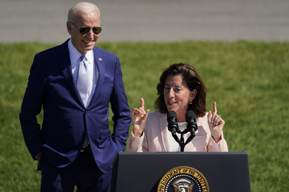 President Joe Biden looks on as Secretary of Commerce Gina Raimondo speaks before the President signs the "CHIPS and Science Act of 2022" during a ceremony on the South Lawn of the White House, Tuesday, Aug. 9, 2022, in Washington. (AP Photo/Carolyn Kaster)