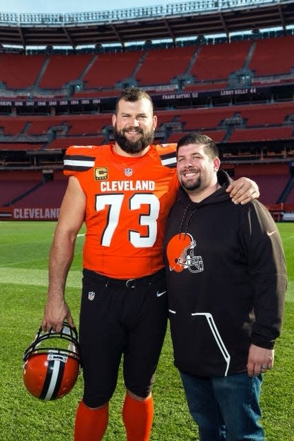 Former Browns left tackle Joe Thomas and Dan Murphy, the team's director of football communications, pose for a photograph at Cleveland Browns Stadium.