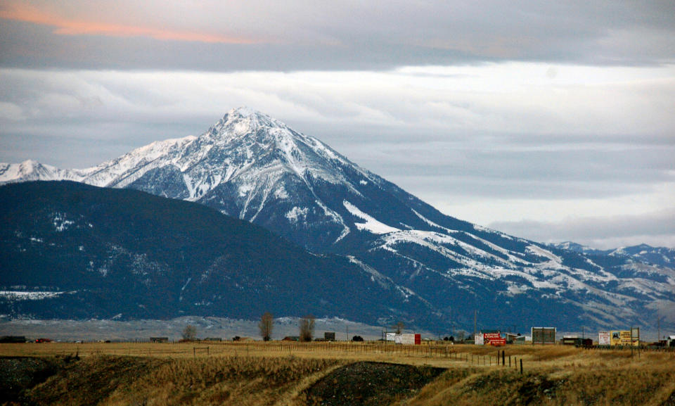 Emigrant Peak towers over the Paradise Valley in Montana north of Yellowstone National Park, on Nov. 21, 2016. Attorneys for a group of youths suing Montana over damages caused by climate change say officials repealed the state's energy policy to avoid an upcoming trial. (AP Photo/Matthew Brown, File)