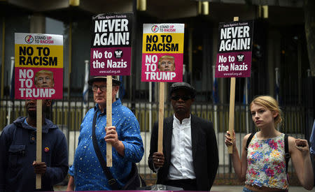 Demonstrators hold placards during an anti-fascist protest outside the U.S Embassy in London, Britain, August 14, 2017. REUTERS/Hannah McKay