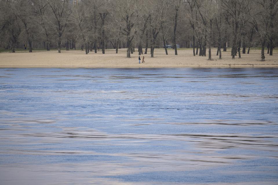 Two women stand on the bank of Dnieper River in Kyiv, Ukraine, Friday, March 22, 2024. (AP Photo/Vadim Ghirda)