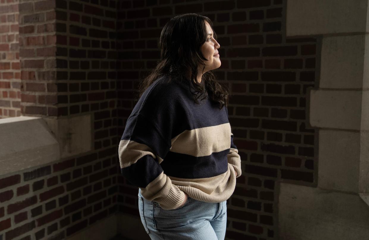 Nallely Segura stands in front of the entrance to Pomerene Hall on Ohio State University's Columbus campus.  A pre-med student, Segura came to Ohio State through an innovative program in her hometown of Immokalee, Florida, where most students come from farmworker families.